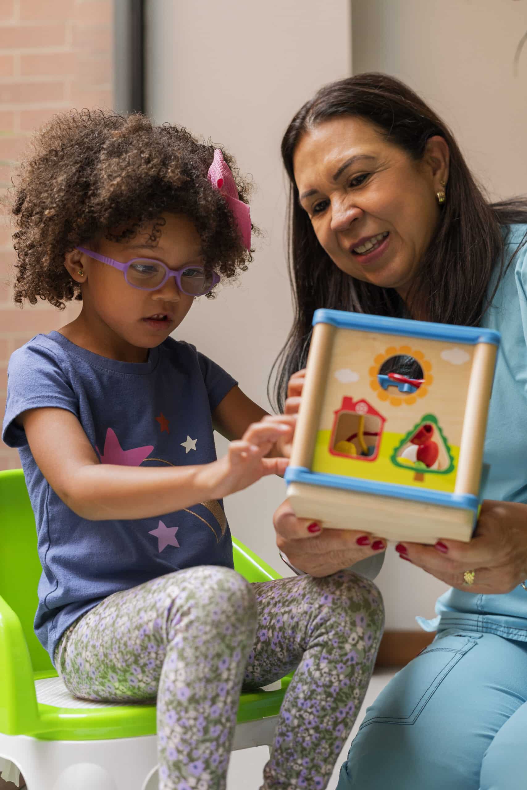 Physiotherapist doctor performs exercises to her patients sensory therapy girls